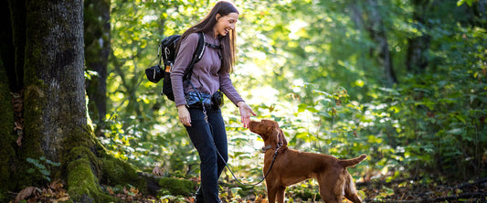 Person walking dog hands-free on a trail in a natural outdoor setting