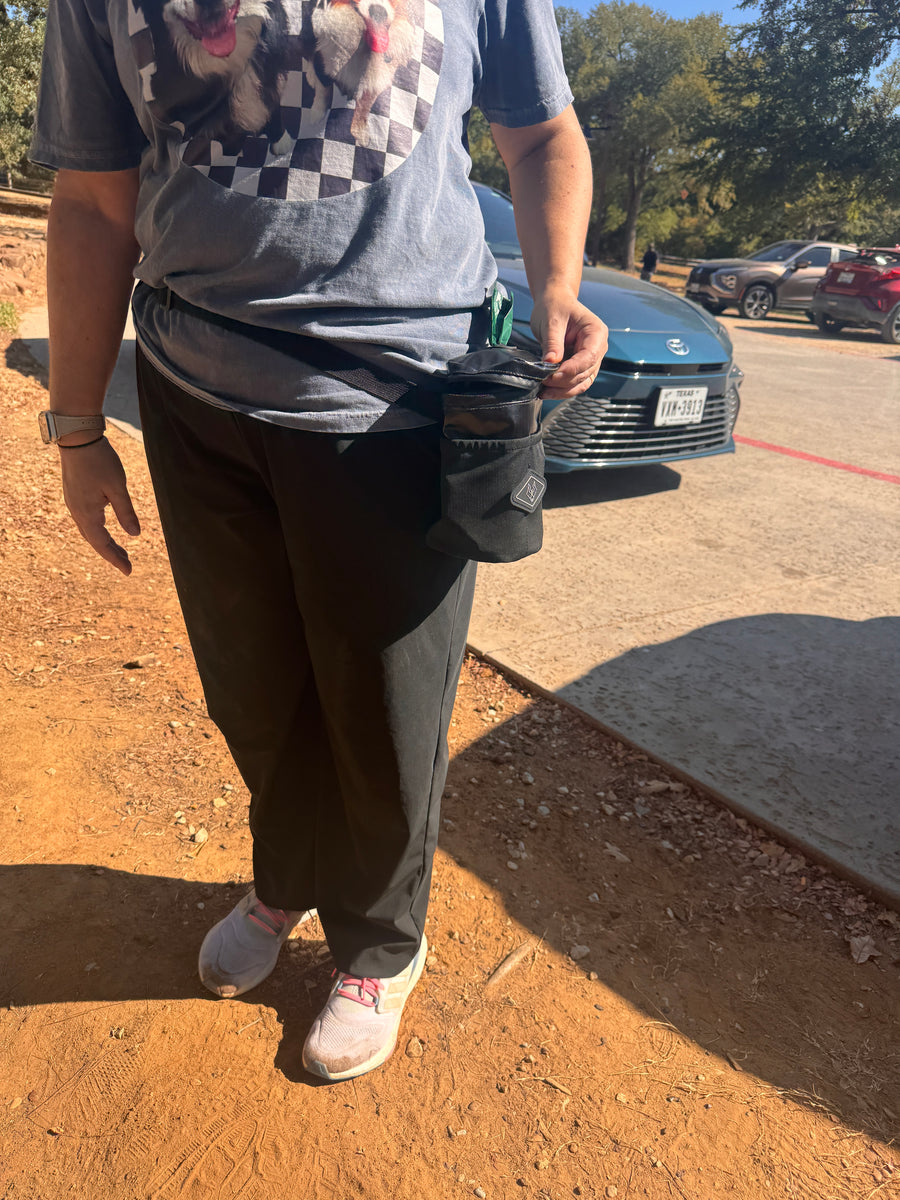 Waste Wrangler Pro in Black worn on the waist belt at a trailhead