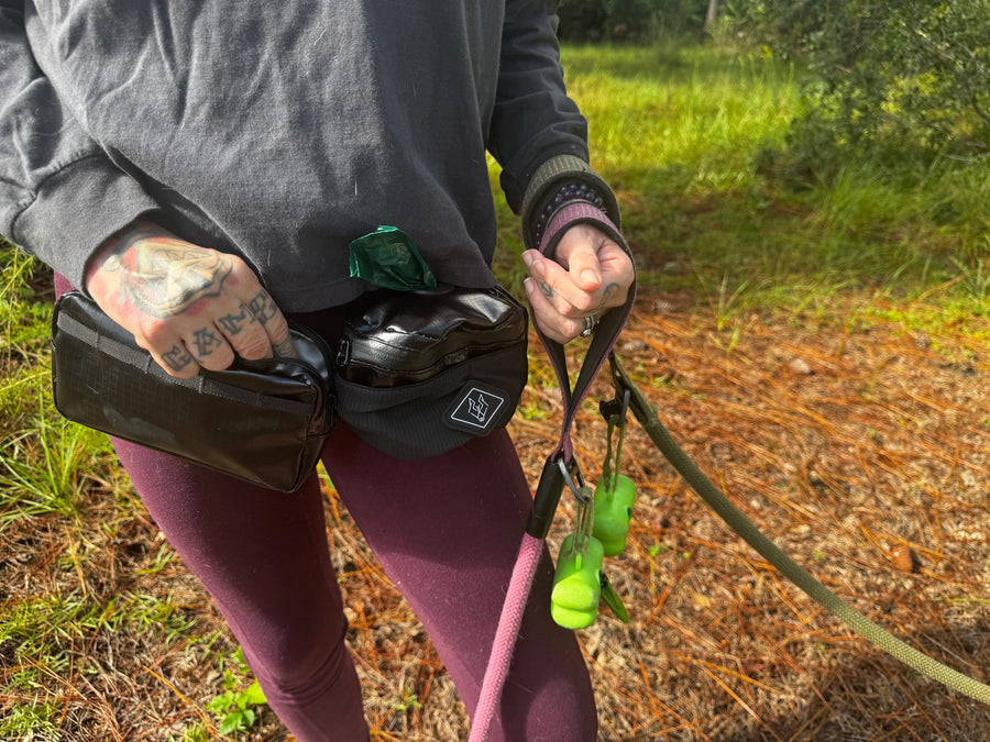 Ultra-light Explorer Kit in use: a customer wearing the Waste Wrangler Mini and Treat Pouch on a walk with her dog